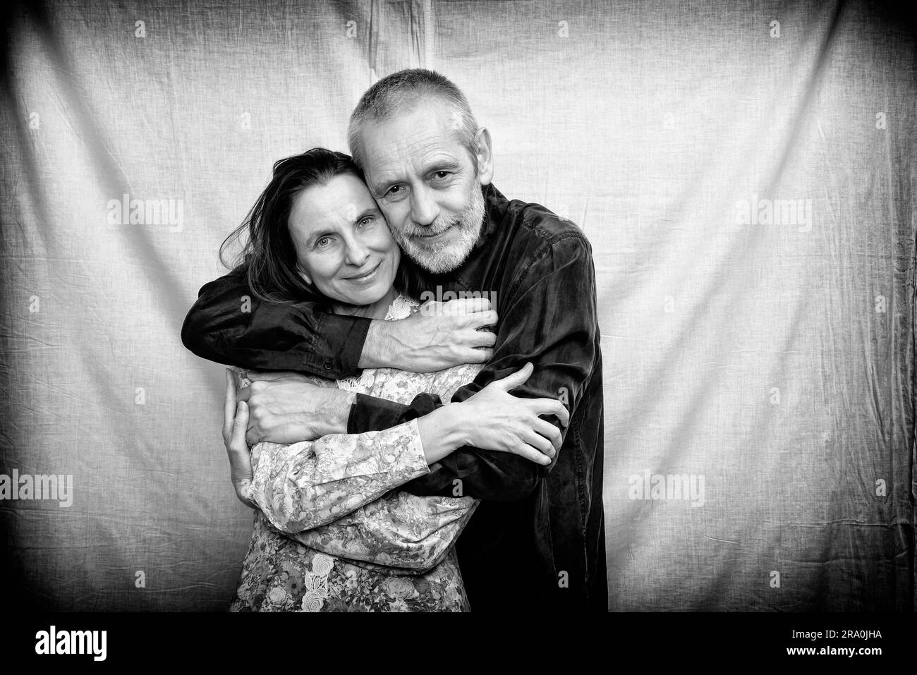 Homme et femme matures heureux avec de longs cheveux souriant pour la Saint-Valentin ou anniversaire et s'embrassant mutuellement. Photo en noir et blanc Banque D'Images