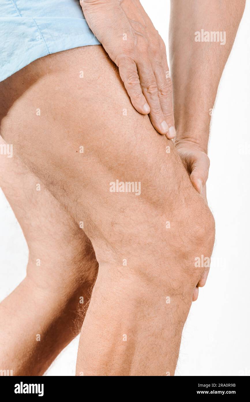 Athlète homme massant un quadriceps douloureux et le genou après un accident sportif. Il pourrait s'agir d'un claquaage musculaire, d'une élongation musculaire, d'un médial Banque D'Images
