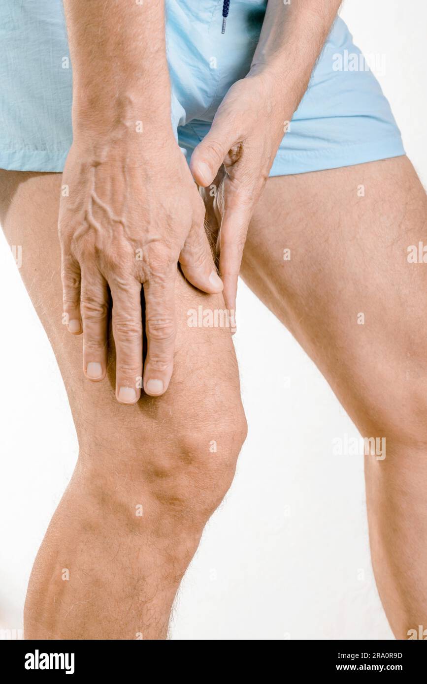 Athlète homme massant un quadriceps douloureux après un accident. Il pourrait s'agir d'un claquaage musculaire ou d'une élongation musculaire Banque D'Images