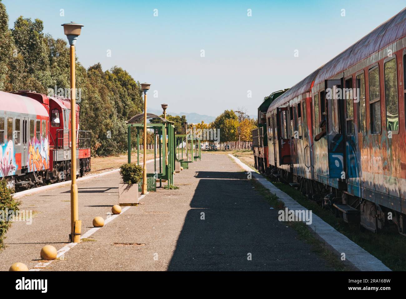 Des locomotives diesel et de vieux wagons couverts de graffitis attendent de partir à la gare de Durrës, sur la côte albanaise Banque D'Images