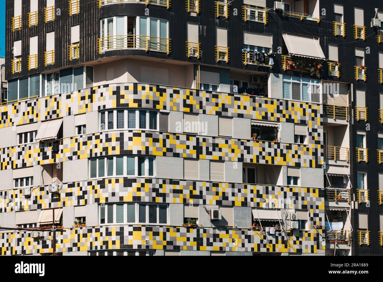 Un immeuble d'appartements moderne à Tirana, Albanie, avec un motif coloré jaune, blanc et gris à l'extérieur Banque D'Images