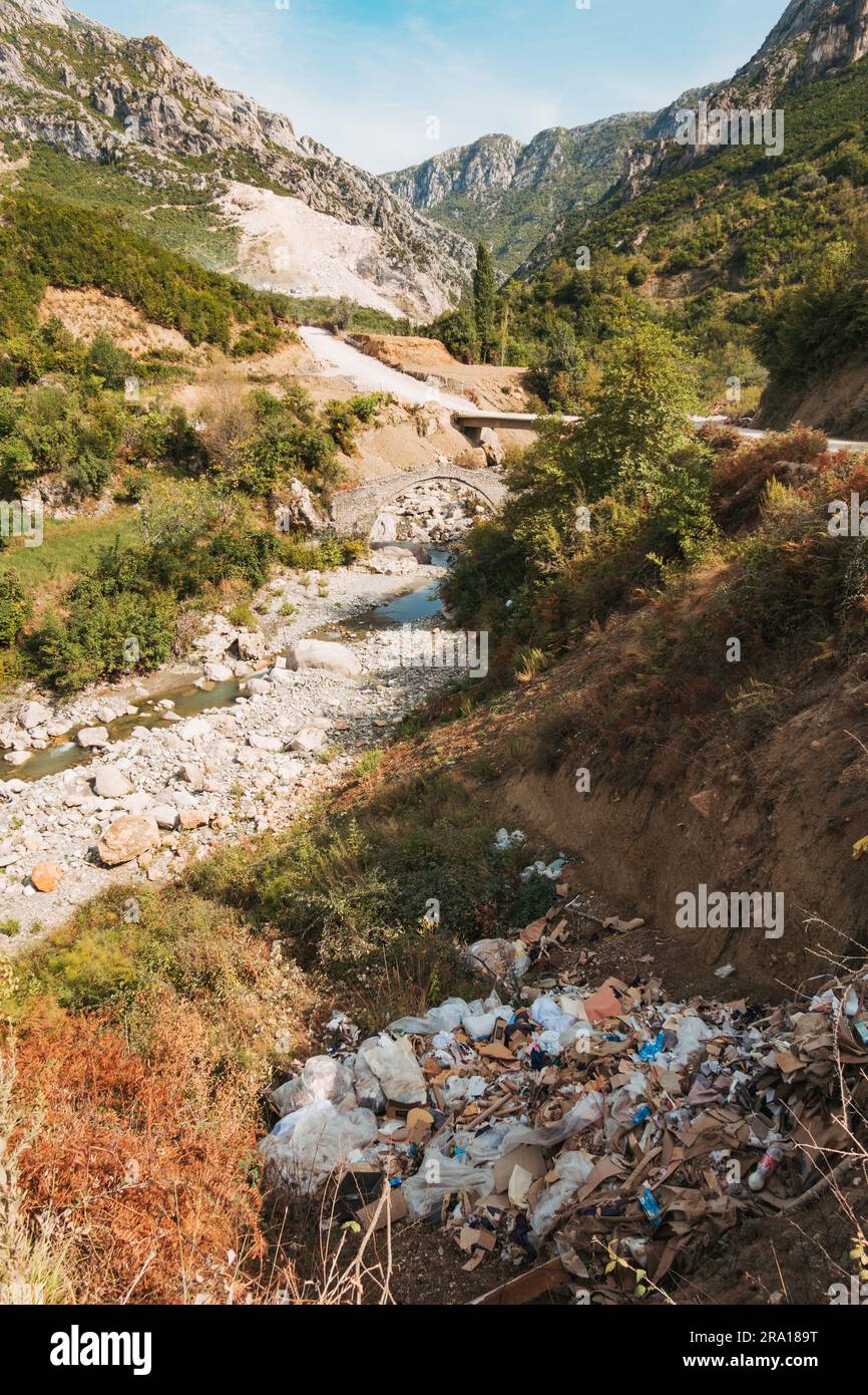 Une pile de déchets qui a été déversée illégalement près d'un pont ottoman historique près de la rivière Zeza près de Kurçaj, en Albanie Banque D'Images