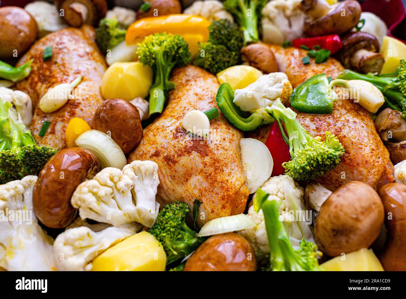 Un repas fraîchement cuit de poulet et de légumes rôtis, dont le brocoli et les pommes de terre Banque D'Images