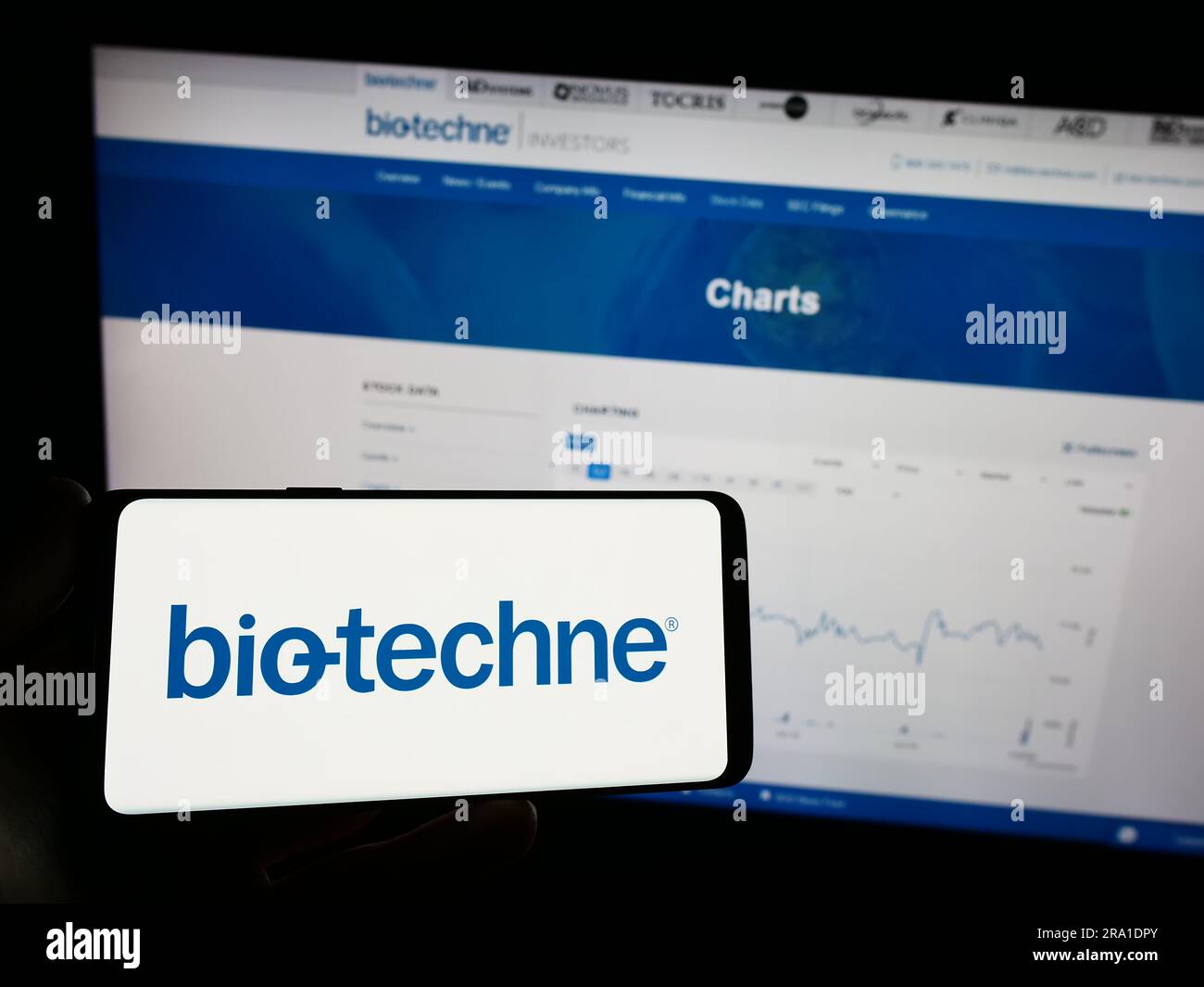 Personne tenant un téléphone portable avec le logo de la société américaine de sciences de la vie Bio-Techne Corporation à l'écran en face de la page Web. Mise au point sur l'affichage du téléphone. Banque D'Images