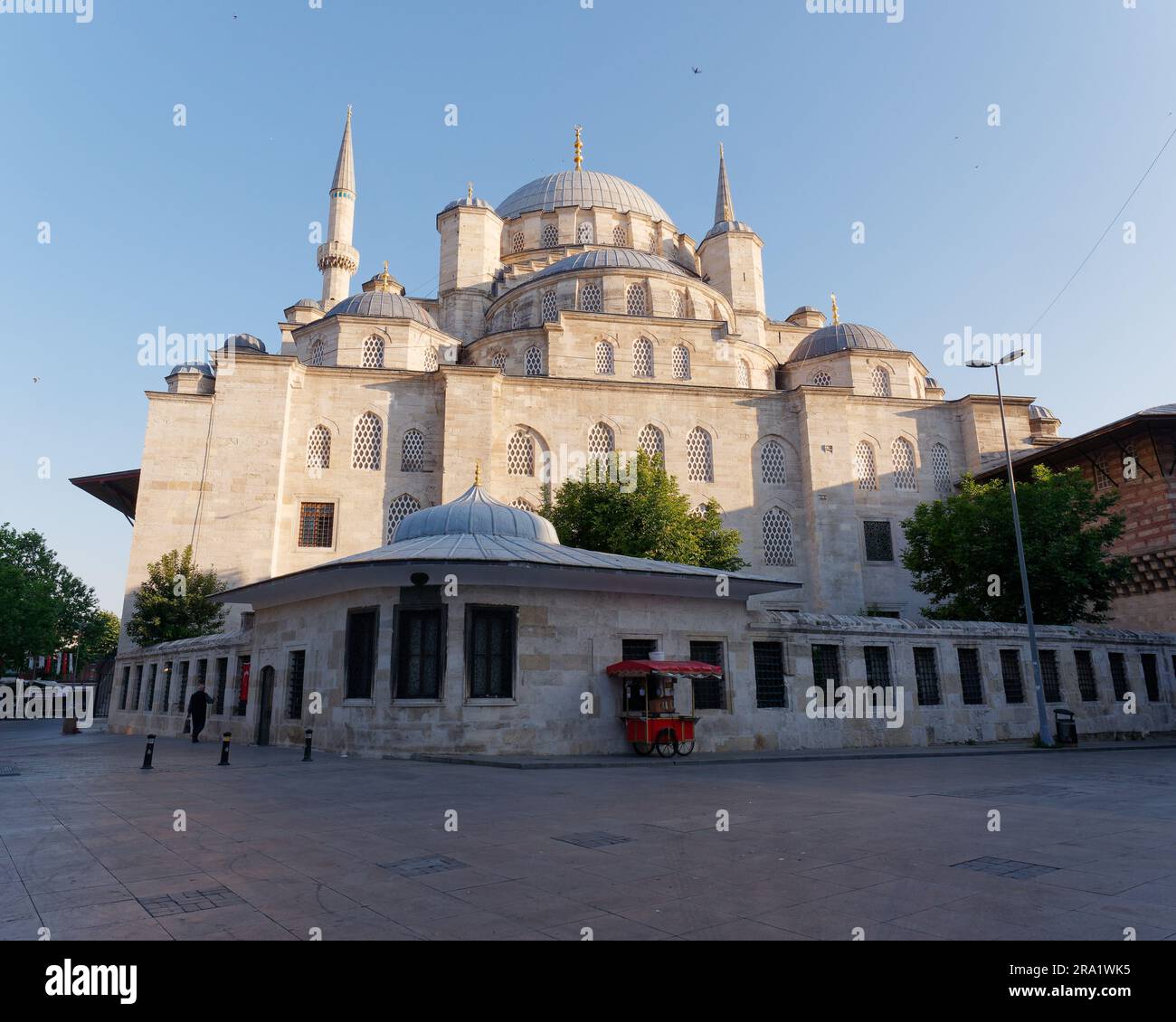 Extérieur de la mosquée Yeni Cami sur un matin d'été et un chariot distributeur rouge Istanbul, Turquie Banque D'Images
