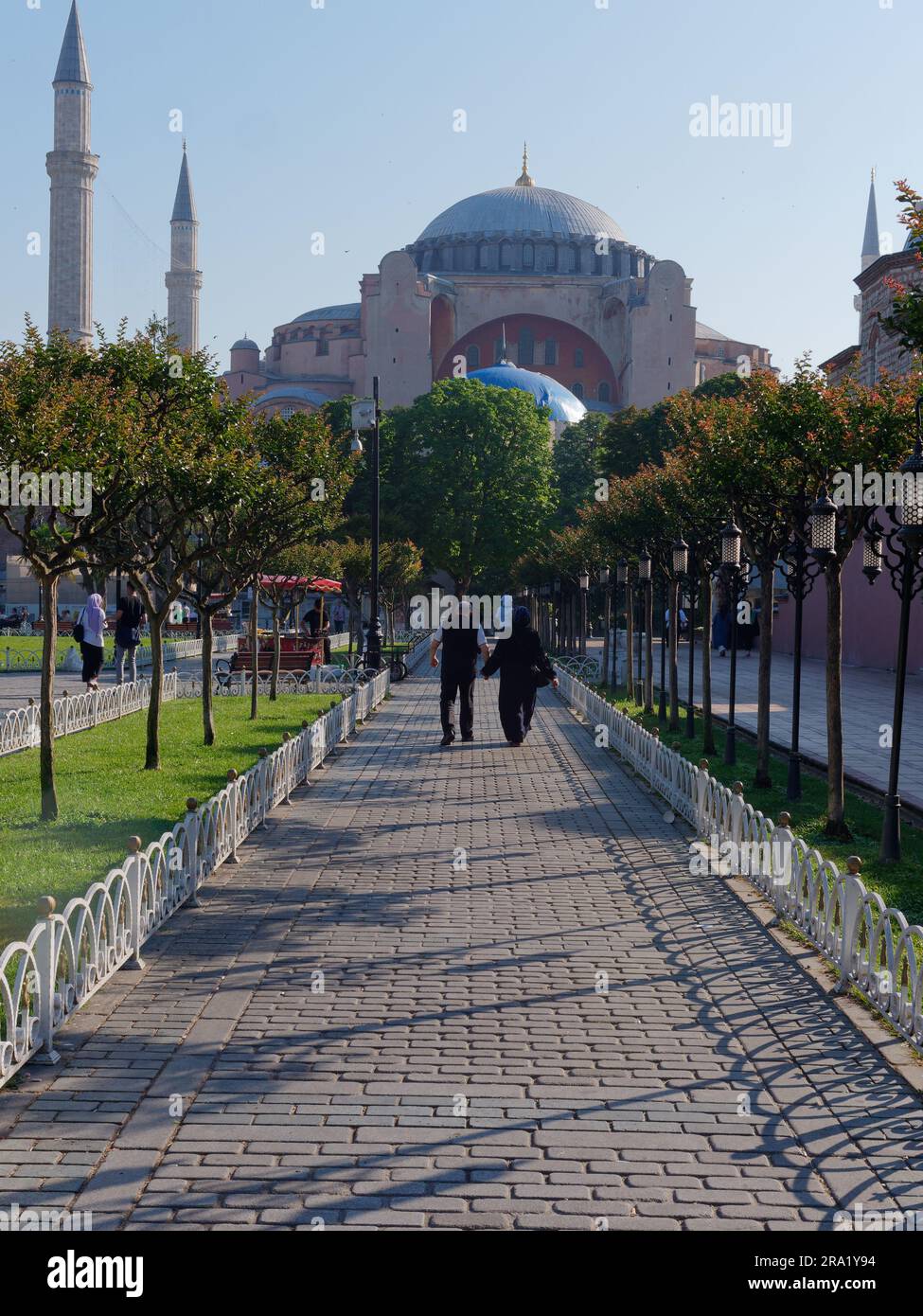 Couple musulman marcher le long d'un chemin de jardin vers la mosquée Sainte-Sophie, quartier Sultanahmet, Istanbul, Turquie Banque D'Images