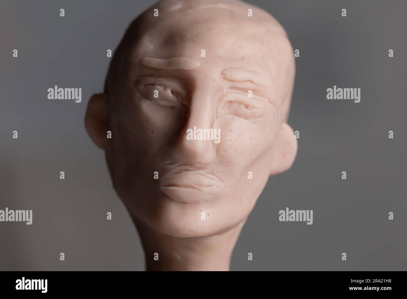 Une sculpture d'une tête avec une expression mélancolique faite de polymère argile Scuppey. Banque D'Images
