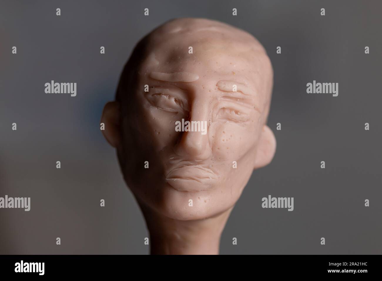 Une sculpture d'une tête avec une expression mélancolique faite de polymère argile Scuppey. Banque D'Images