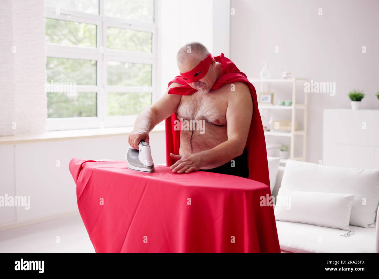 Vêtements de repassage super-héros amusants. Concept de réussite homme Banque D'Images