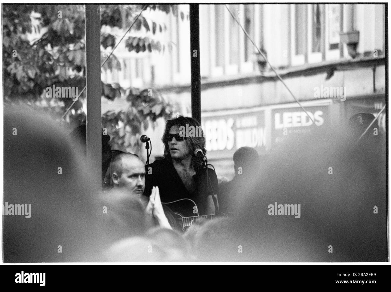 BON JOVI, CONCERT GRATUIT, CARDIFF BANDSTAND, 1995 : Jon bon Jovi de bon Jovi jouant un concert de busking gratuit sur Queen Street, Cardiff, pays de Galles, Royaume-Uni le 21 juin 1995. Le concert était de faire connaître le concert mal vendu au Arms Park Stadium le lendemain et une foule énorme s'est rassemblée dans la principale rue commerçante de Cardiff. Photo : Rob Watkins Banque D'Images