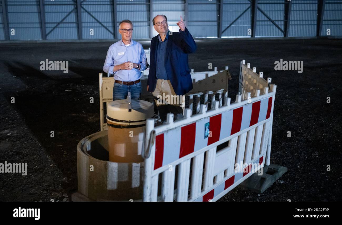 Munster, Allemagne. 30th juin 2023. Friedrich-Wilhelm Otte (l), chef de projet pour l'étang de Dethlingen, présente Christian Meyer (Bündnis 90/Die Grünen), ministre de l'environnement de Basse-Saxe, un site de forage dans la salle de sauvetage au-dessus de l'étang de Dethlingen. Dans la lande de Lüneburg, les sites contaminés polluent le sol et les eaux souterraines. Les armes chimiques de la Wehrmacht doivent maintenant être récupérées de l'étang de Dethlingen. Credit: Philipp Schulze/dpa/Alamy Live News Banque D'Images