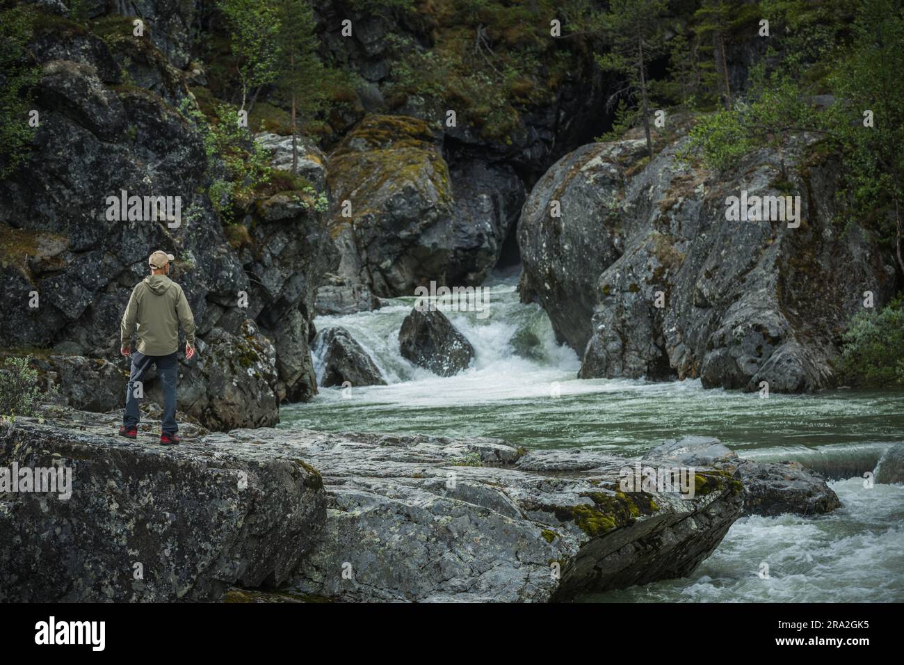 Touriste caucasien dans sa 40s exploration des cascades pittoresques et des gorges de la rivière Rocky dans la région sauvage norvégienne. Thème extérieur. Banque D'Images