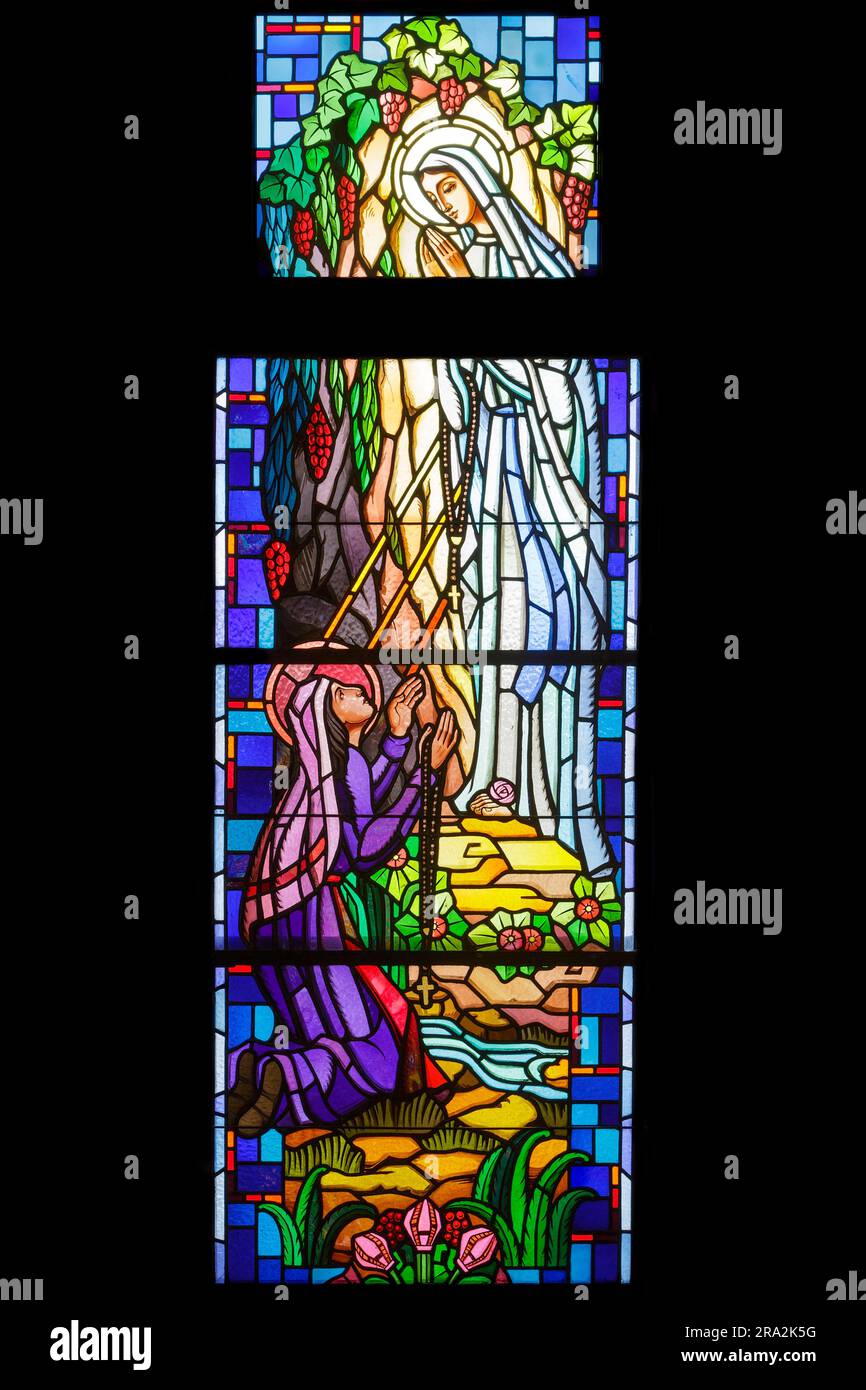 France, Meurthe et Moselle, Nancy, chapelle de la Vierge Marie et Saint Joseph de l'ancien couvent des Soeurs de la Sainte enfance de Marie (sœurs de l'enfance houleuse de Marie) puis des Soeurs de l'Alliance construit en 1875 par l'architecte Léon Vautrin, Aujourd'hui, le centre de documentation et la salle polyvalente de l'école de formation professionnelle Claude Daunot, boulevard Georges Clemenceau, vitraux de l'atelier de Benoit Freres (frères Benoit) réalisé en 1949, représentant l'histoire historique de l'apparition de la Vierge Marie à Sainte Bernadette Soubirous Banque D'Images