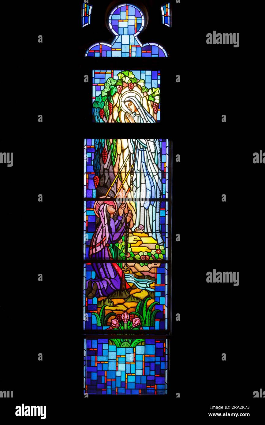France, Meurthe et Moselle, Nancy, chapelle de la Vierge Marie et Saint Joseph de l'ancien couvent des Soeurs de la Sainte enfance de Marie (sœurs de l'enfance houleuse de Marie) puis des Soeurs de l'Alliance construit en 1875 par l'architecte Léon Vautrin, Aujourd'hui, le centre de documentation et la salle polyvalente de l'école de formation professionnelle Claude Daunot, boulevard GeorgesClemenceau, vitraux de l'atelier de Benoit Freres (frères Benoit) réalisé en 1949, représentant l'histoire historique de l'apparition de la Vierge Marie à Sainte Bernadette Soubirous Banque D'Images