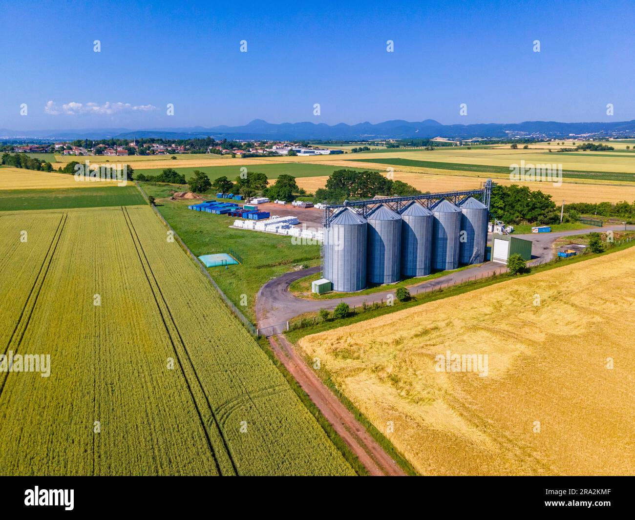 France, Puy de Dome, champs de céréales et silos à grains, plaine de la Limagne, près de Riom, chaîne des Puys en arrière-plan (vue aérienne) Banque D'Images