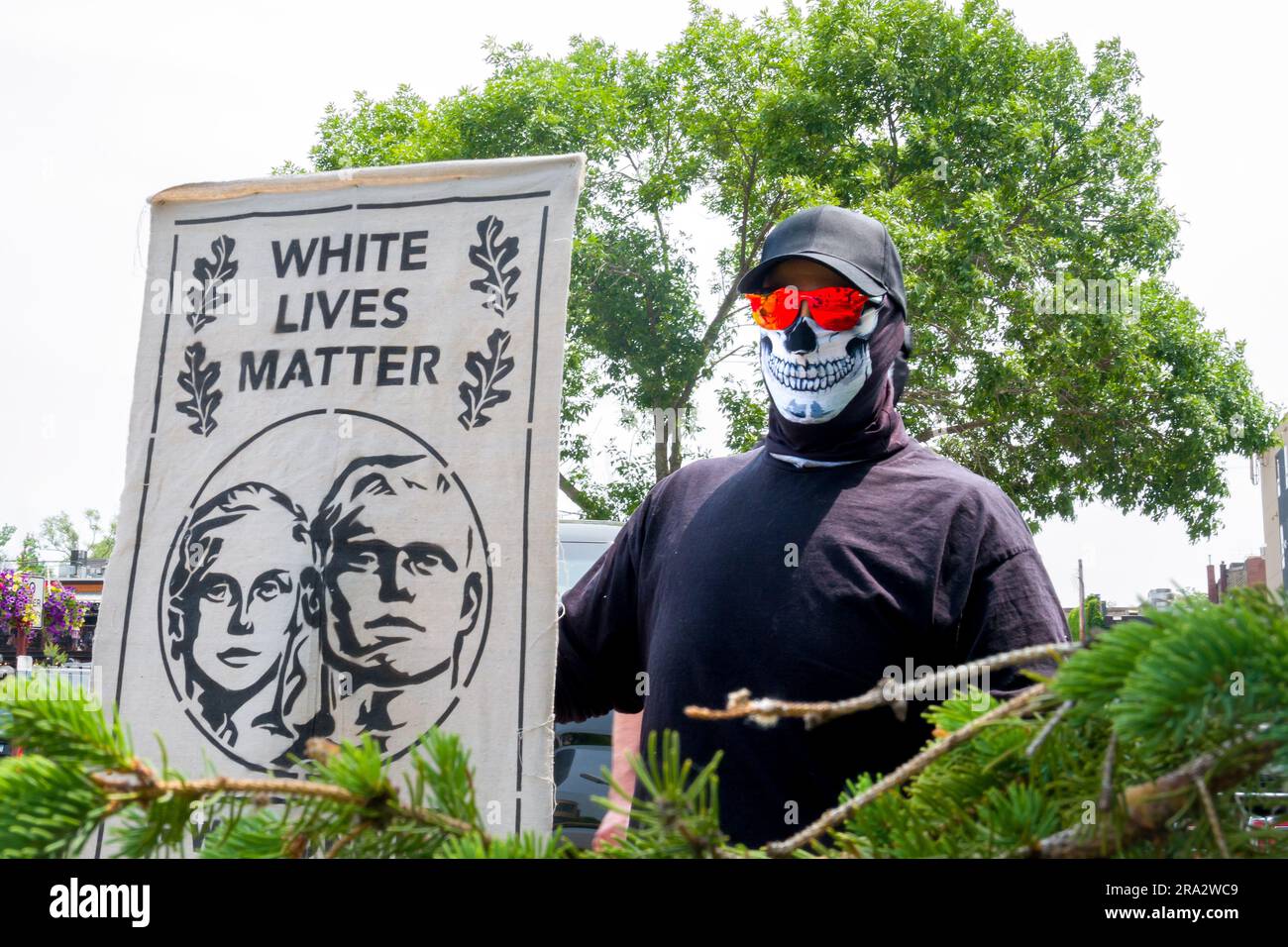 HUDSON, WI, États-Unis - 17 JUIN 2023 : personne masquée non identifiée tenant la bannière de la matière de la vie blanche à la célébration de la fierté d'Hudson. Banque D'Images