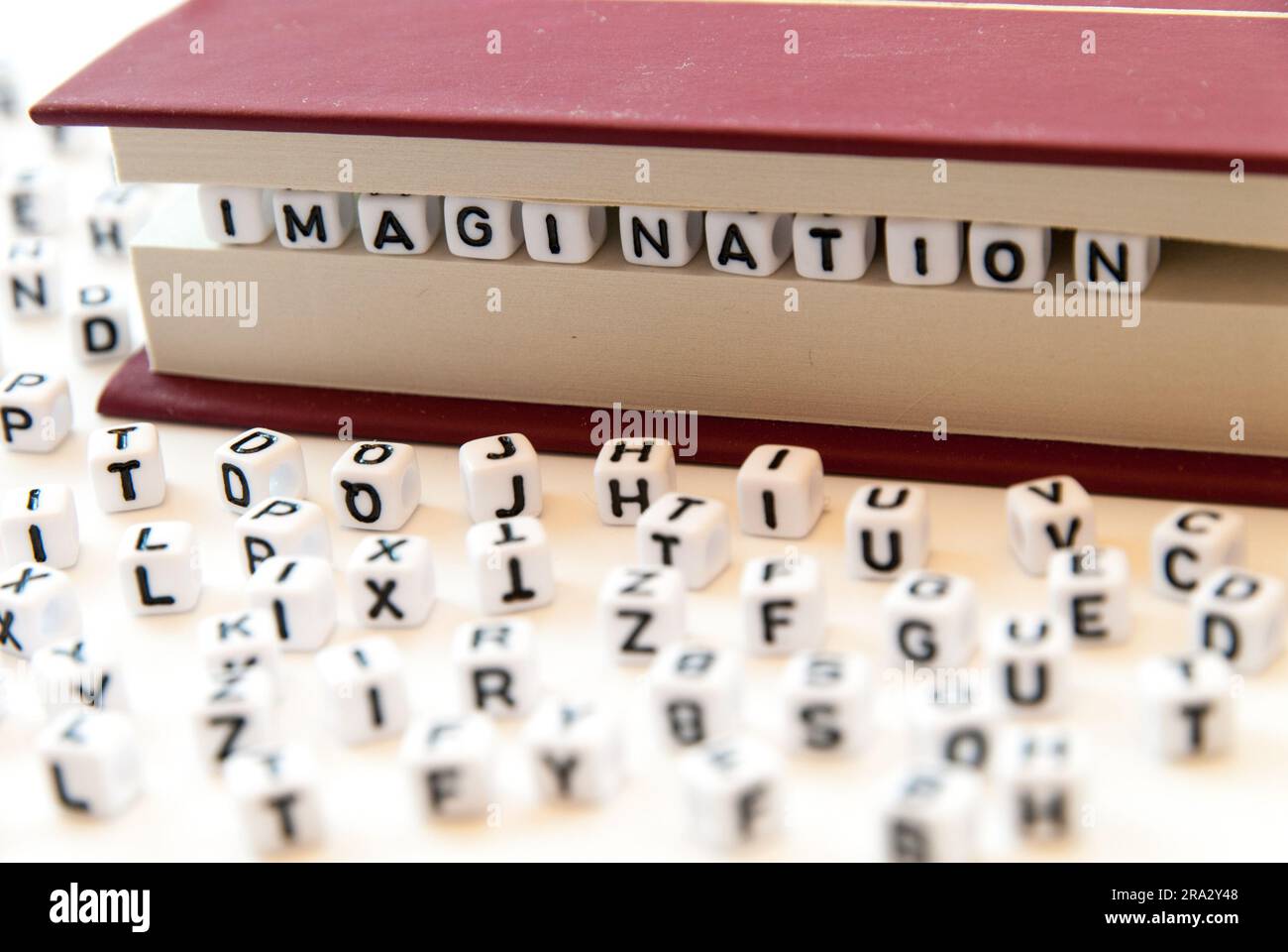 Mot imagination écrit avec des lettres entre un livre pages fond blanc avec des lettres réparties autour de l'éducation lecture concept Banque D'Images