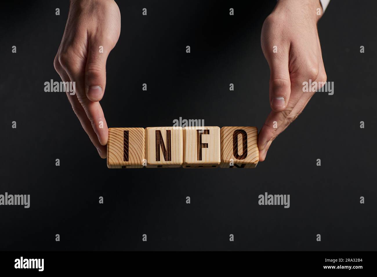 Main examine les mots INFO à travers une loupe sur un Bla Banque D'Images