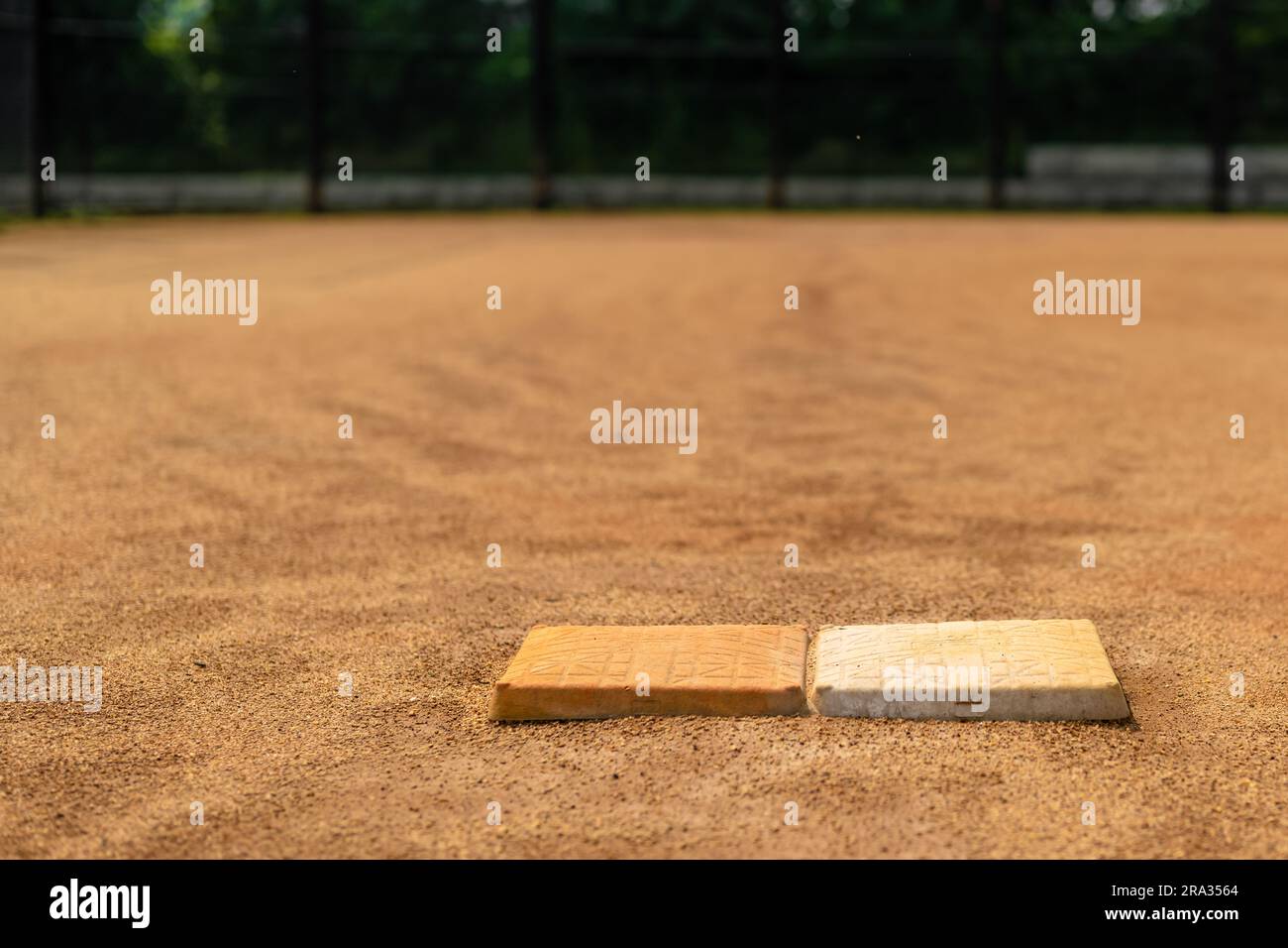 Vue du terrain de softball en argile patiné première base avec double sac de sécurité, en regardant vers la plaque d'origine. Banque D'Images