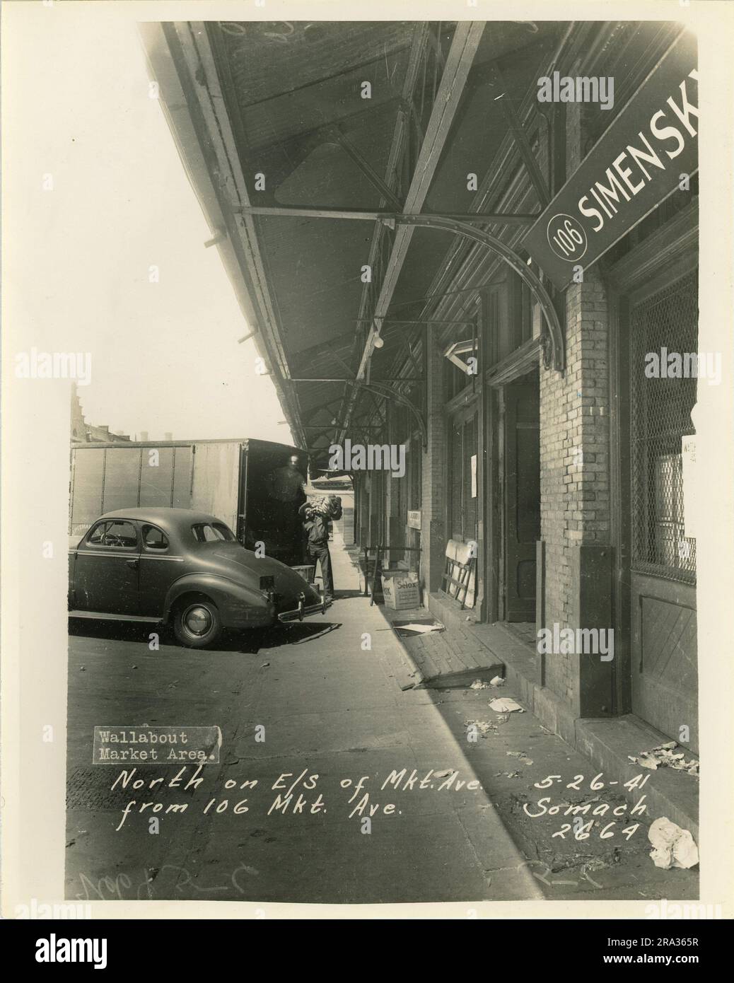 Photographier les bâtiments du marché à l'extérieur, en regardant vers le nord, sur le côté est de l'avenue MKT, à partir du 106, avenue MKT, avec deux hommes travaillant. Banque D'Images