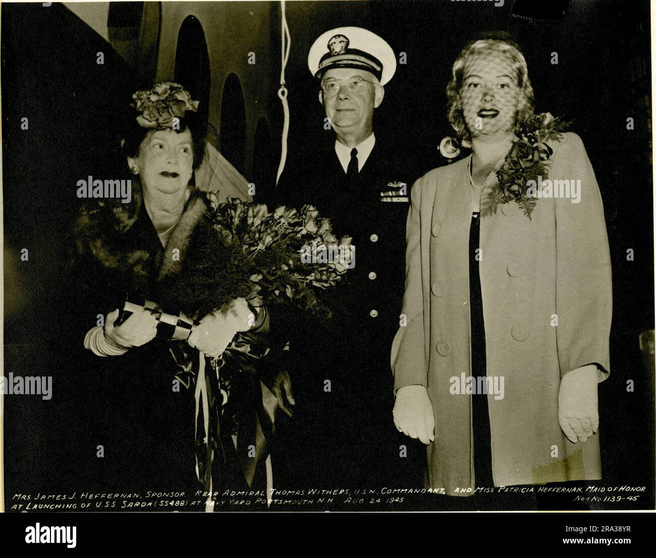 Mme James J. Heffernan, contre-amiral Thomas Withers, et Mlle Patricia Heffernan au lancement de l'USS Sarde. Légende originale : Mme James J. Heffernan, commanditaire, contre-amiral Thomas Withers, USN, et Mlle Patricia Heffernan, femme d'honneur, au lancement de l'USS Sarde à Navy Yard, Portsmouth, N.H. le 24 août 1945. 1945-08-24T00:00:00. Banque D'Images