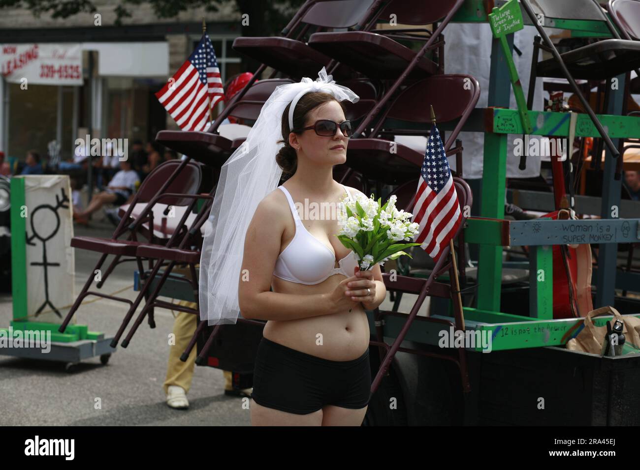 Une femme sous le voile d’une mariée, mais portant un soutien-gorge, pas de chemise, se prépare à défilé avec Beanpole, Dieu de comportement inutile, lors de la parade du 4th juillet sur 4 juillet 2006 à Bloomington, dans l’Indiana. (Photo de Jeremy Hogan) Banque D'Images