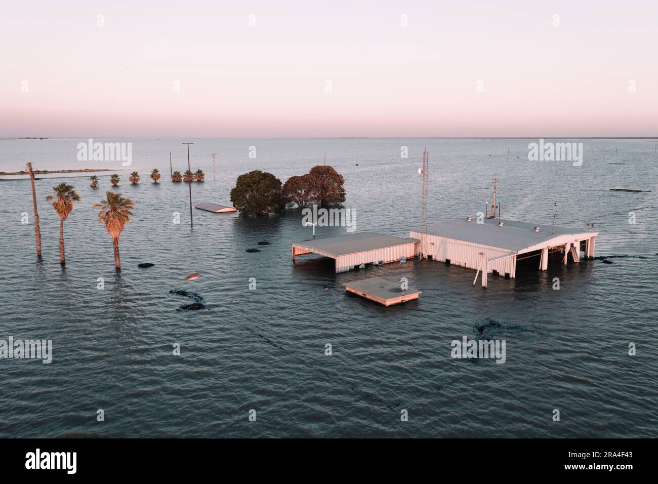 Les ranchs inondés et le matériel agricole couvrent une vaste étendue de la vallée centrale de Californie. Le lac Tulare était autrefois le plus grand plan d'eau douce de l'Ouest américain. Il s’est asséché il y a un siècle après que ses affluents aient été damés, dikés et détournés et que le lit du lac ait été converti en une des terres agricoles les plus fertiles et productives de Californie. En 2023, le lac Tulare a fait une réapparition surprise après un hiver de pluies exceptionnellement fortes, inondant quelque 180 000 kilomètres carrés de terres agricoles dans la vallée centrale. Les experts croient qu'il faudra peut-être deux ou trois ans pour que les eaux inondées se soient retirées. Banque D'Images