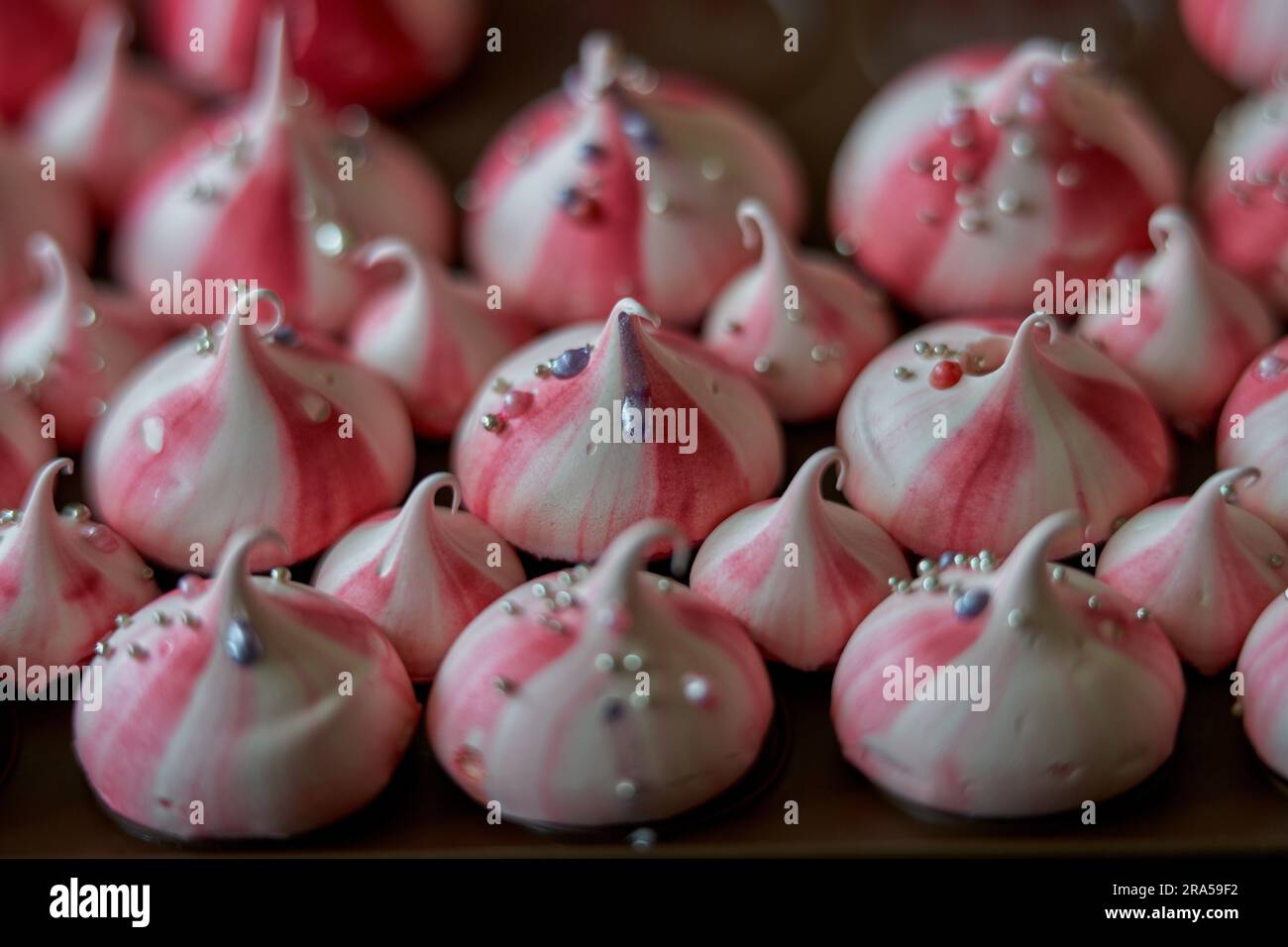 Meringues faites maison avec des rayures rouges et des boules de sucre argentées Banque D'Images