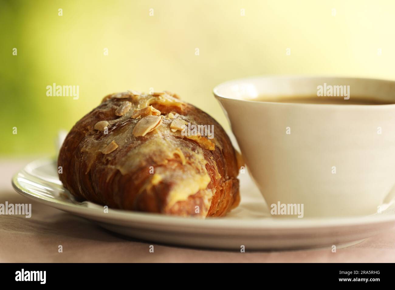 Un croissant aux amandes et une tasse de café Banque D'Images