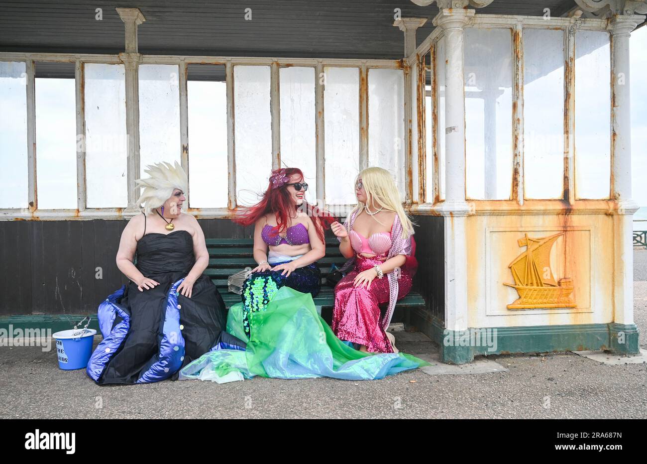 Brighton UK 1st juillet 2023 - les Mermaids ont le temps de discuter avant de participer à la marche du défilé des Mermaids le long de Brighton front aujourd'hui . Le défilé annuel est une célébration de la mer et de la sensibilisation à la conservation marine et de maintenir l'eau propre : crédit Simon Dack / Alamy Live News Banque D'Images