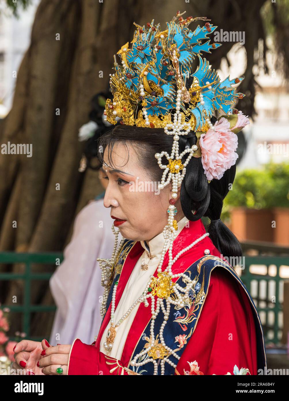 Hong Kong, Chine -- 11 mars 2023. Une femme à l'aspect royal modélise des vêtements de mariage chinois traditionnels dans un parc. Banque D'Images