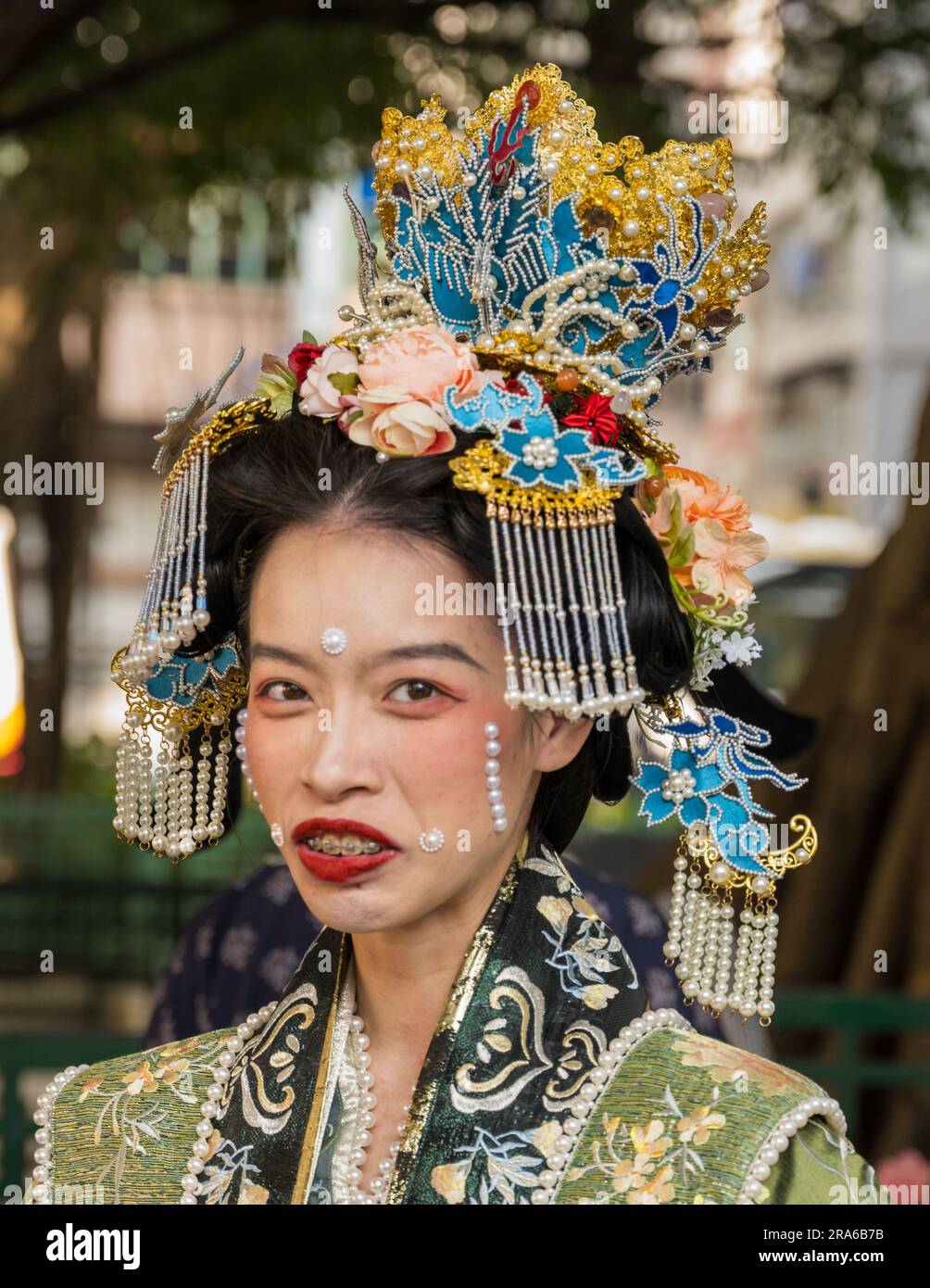 Hong Kong, Chine -- 11 mars 2023. Porrait d'une femme chinoise avec des bretelles et un coiffeur élaboré portant une tenue de mariage. Banque D'Images