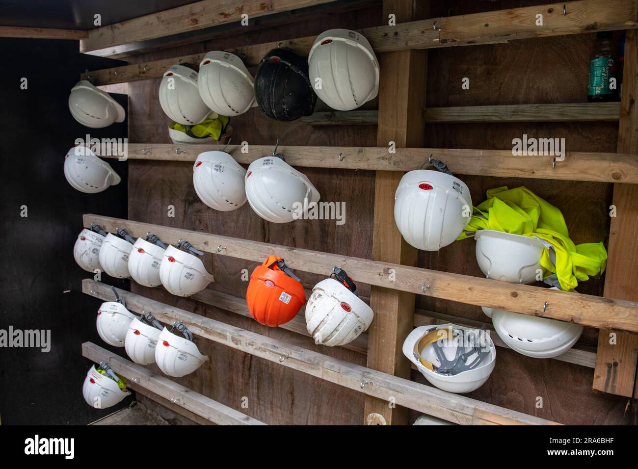 Les casques de sécurité font partie des EPI obligatoires portés sur les chantiers de construction et de construction au Royaume-Uni. Voici quelques étagères avec des chapeaux. Banque D'Images