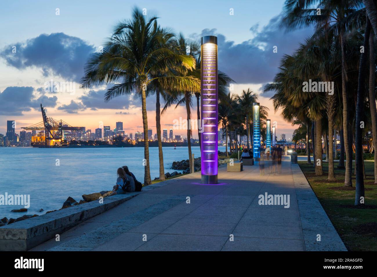 Miami Beach, Floride, États-Unis. Vue le long du sentier illuminé dans South Pointe Park, South Beach, crépuscule, centre-ville de Miami en arrière-plan. Banque D'Images