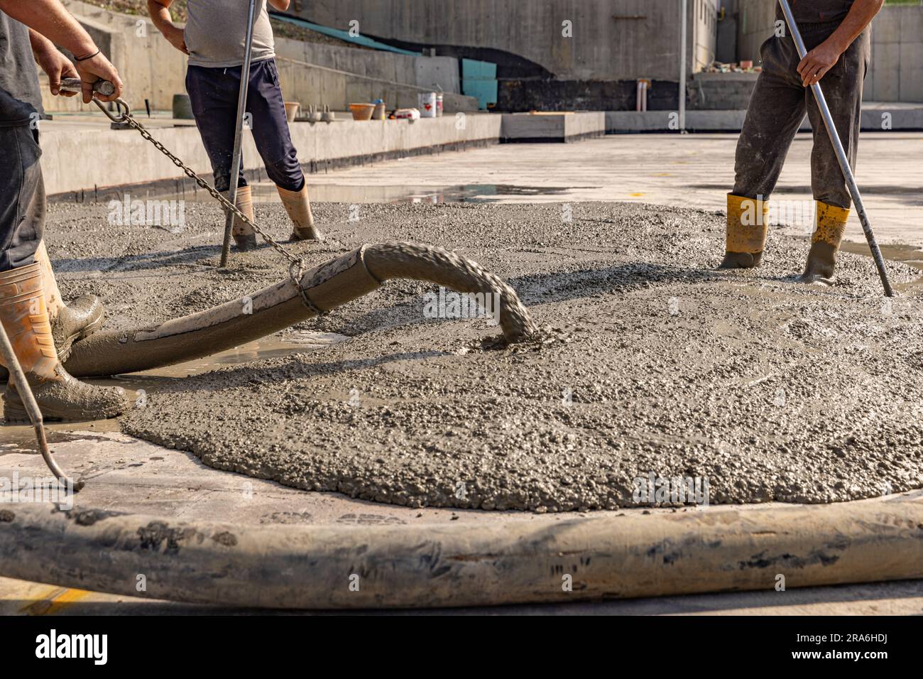 Ouvrier de construction versant un bétonné humide sur le chantier de construction Banque D'Images