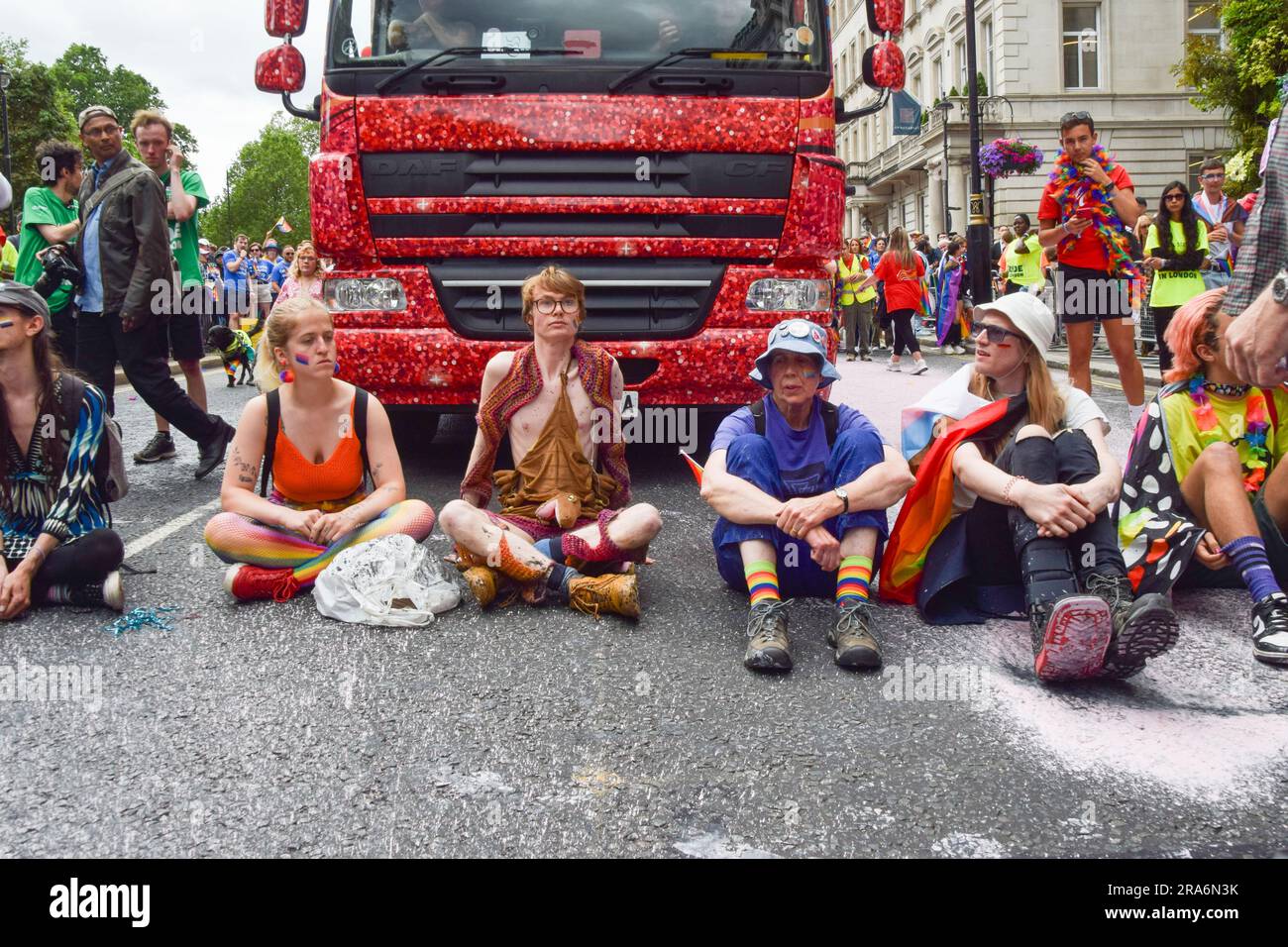Londres, Royaume-Uni. 01st juillet 2023. Les manifestants s'assoient et bloquent la route pendant la manifestation. Les activistes de Just Stop Oil de la communauté LGBTQ ont pulvérisé de la peinture rose et bloqué la parade de la fierté à Londres en s'asseyant devant un camion Coca-Cola prenant part à la parade, en signe de protestation contre la fierté travaillant avec des industries liées à la crise climatique et en signe de protestation contre Coca-Cola, considéré comme le plus grand pollueur de plastique au monde. Crédit : SOPA Images Limited/Alamy Live News Banque D'Images