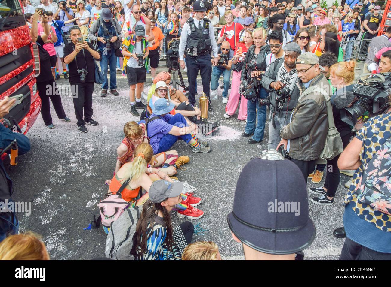Londres, Royaume-Uni. 01st juillet 2023. Les manifestants s'assoient et bloquent la route pendant la manifestation. Les activistes de Just Stop Oil de la communauté LGBTQ ont pulvérisé de la peinture rose et bloqué la parade de la fierté à Londres en s'asseyant devant un camion Coca-Cola prenant part à la parade, en signe de protestation contre la fierté travaillant avec des industries liées à la crise climatique et en signe de protestation contre Coca-Cola, considéré comme le plus grand pollueur de plastique au monde. Crédit : SOPA Images Limited/Alamy Live News Banque D'Images