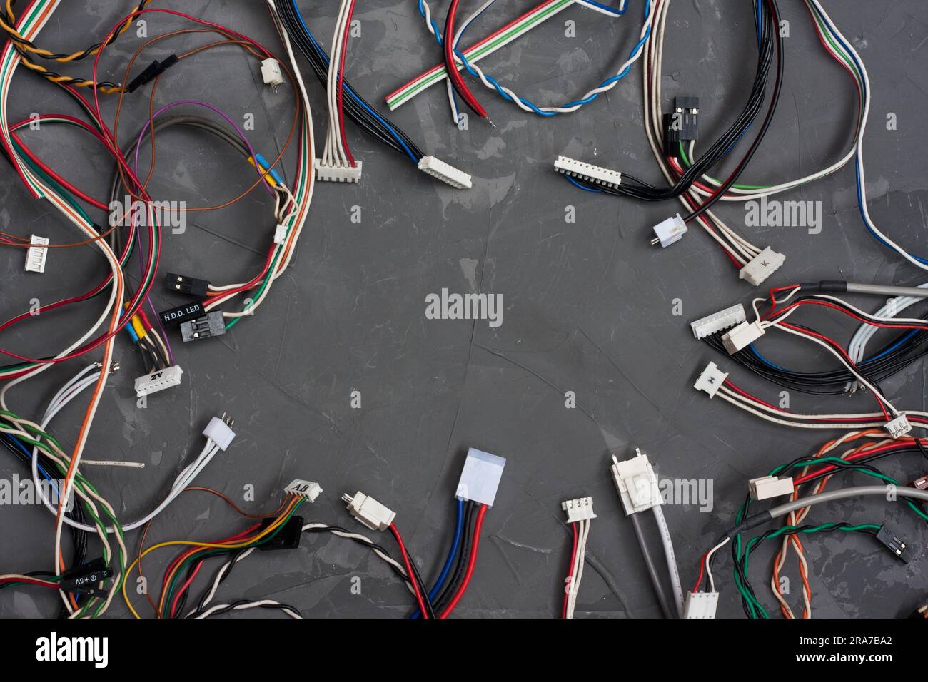 Câbles et fils de couleur avec connecteurs sur fond de béton gris. ordinateur coloré et autres fils. Télécommunications. Vide pour post Banque D'Images