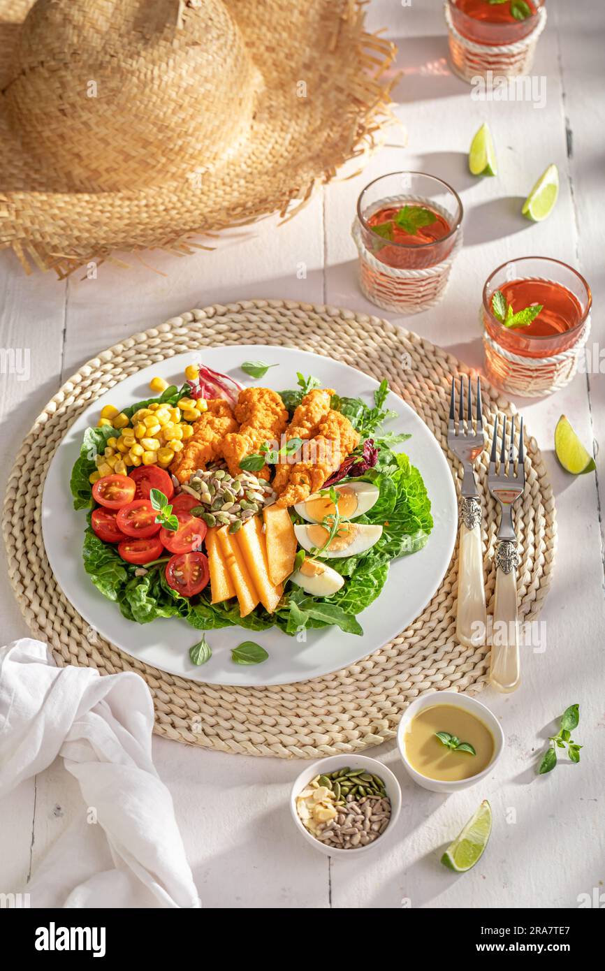 Salade maison servie dans le jardin avec limonade. Salade de poulet, légumes et fruits. Banque D'Images