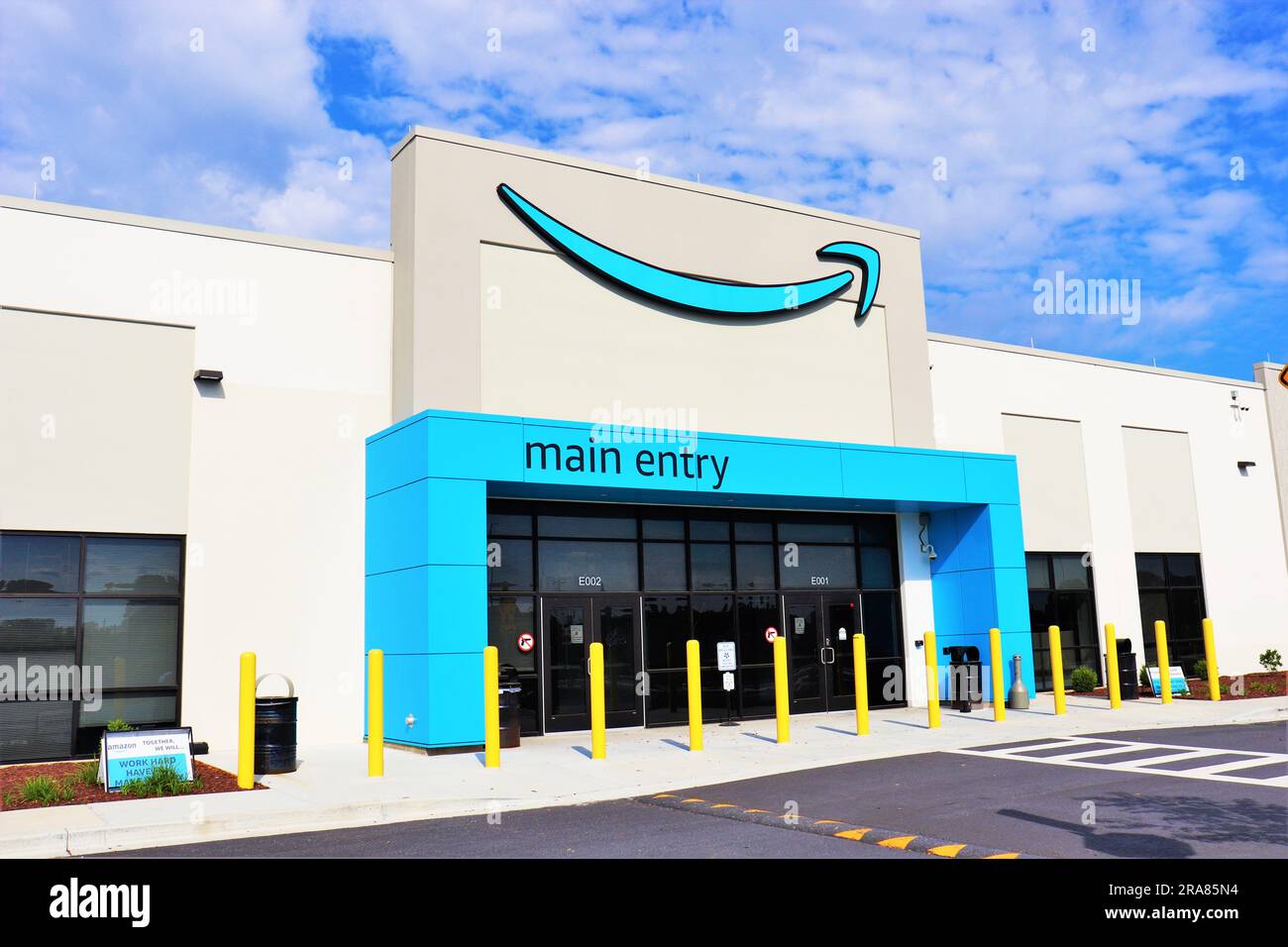 Entrée principale du nouveau bâtiment d'entrepôt Amazon avec logo de sourire de flèche. Banque D'Images