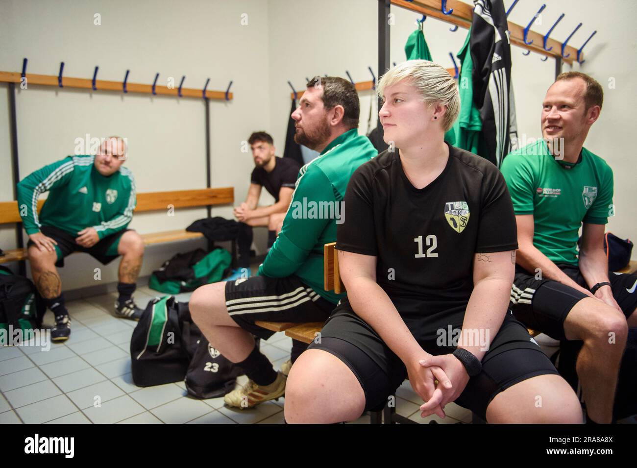 PRODUCTION - 01 juillet 2023, Basse-Saxe, Deblinghausen: Joueur de football amateur Céline Saßnick (2nd de droite) est assis avec ses coéquipiers de l'équipe de tus Steyerberg dans le dressing du gymnase local avant le match contre SV Rot Weiß Deblinghausen. Saßnick, 28 ans, travaille depuis 17 ans avec le tus Steyerberg dans le district de Nienburg/Weser. Elle est actuellement un buteur pour la troisième équipe masculine de la troisième division de district. Parfois, elle aide également dans la deuxième équipe, une division ci-dessus. Toutefois, cela n'a été possible que pour elle depuis décembre. Depuis, les femmes en Basse Sax Banque D'Images