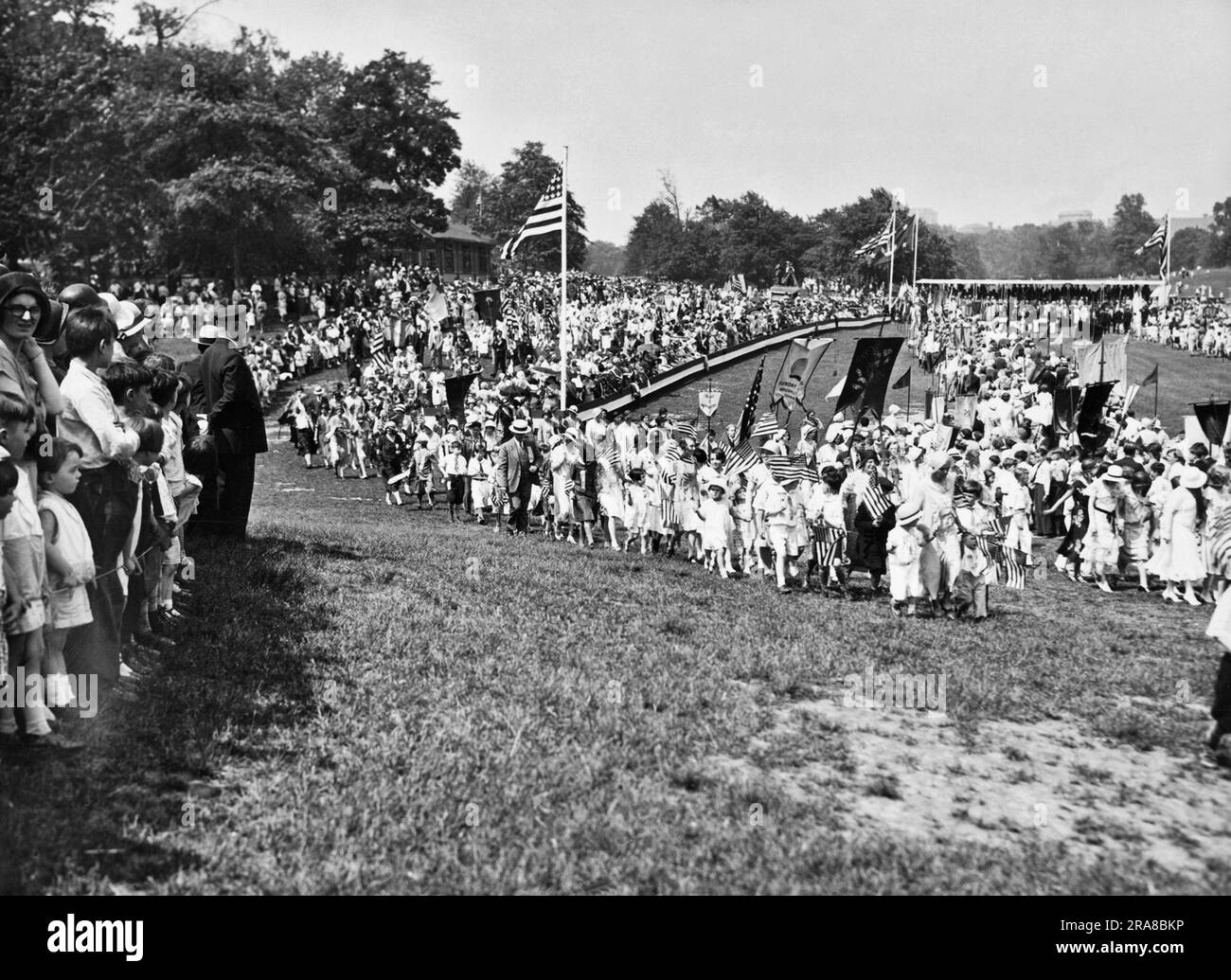 New York, New York : c. 1928 plus de 100 000 élèves de l'école du dimanche de Brooklyn de 360 églises ont défilé dans diverses parties du quartier lors du défilé anniversaire de 102nd de l'Union scolaire du dimanche de Brooklyn. Une partie de la parade passe devant le stand de revue dans Prospect Park. Banque D'Images