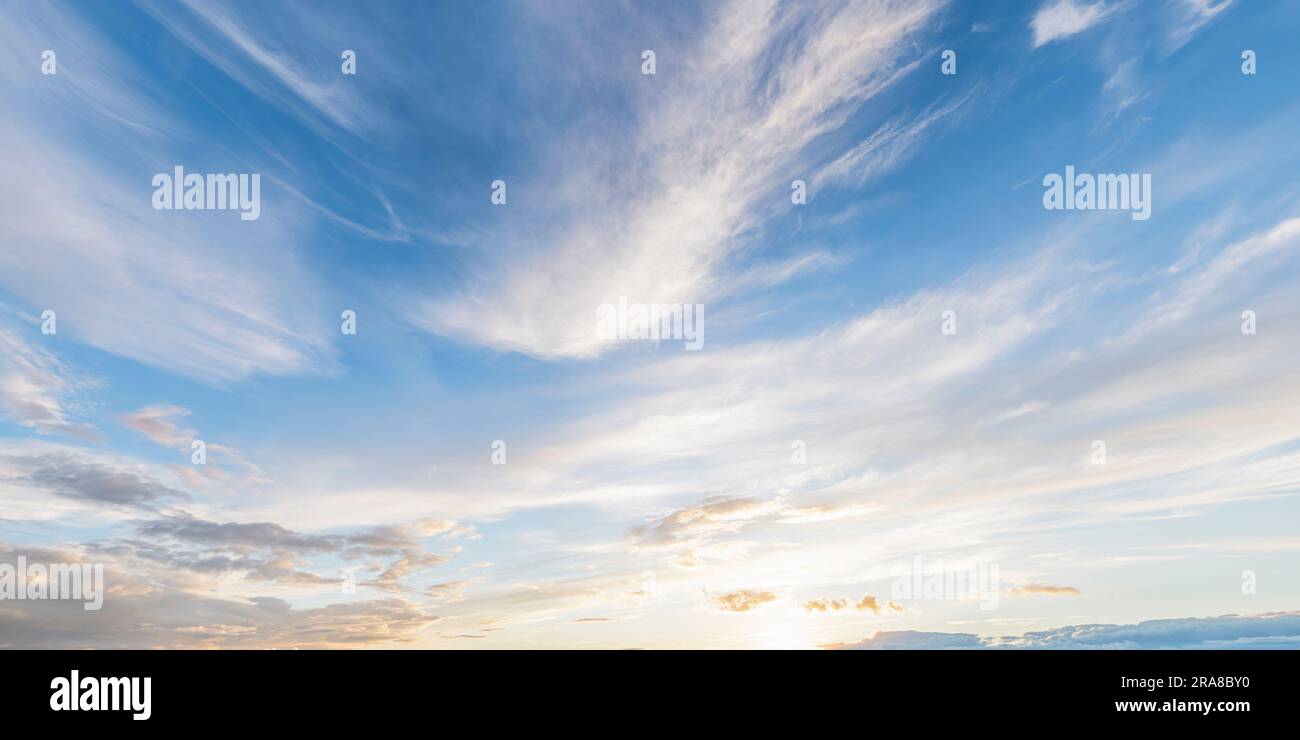 Ciel bleu au coucher du soleil avec des nuages de cirrus et d'autres formes de nuages Banque D'Images