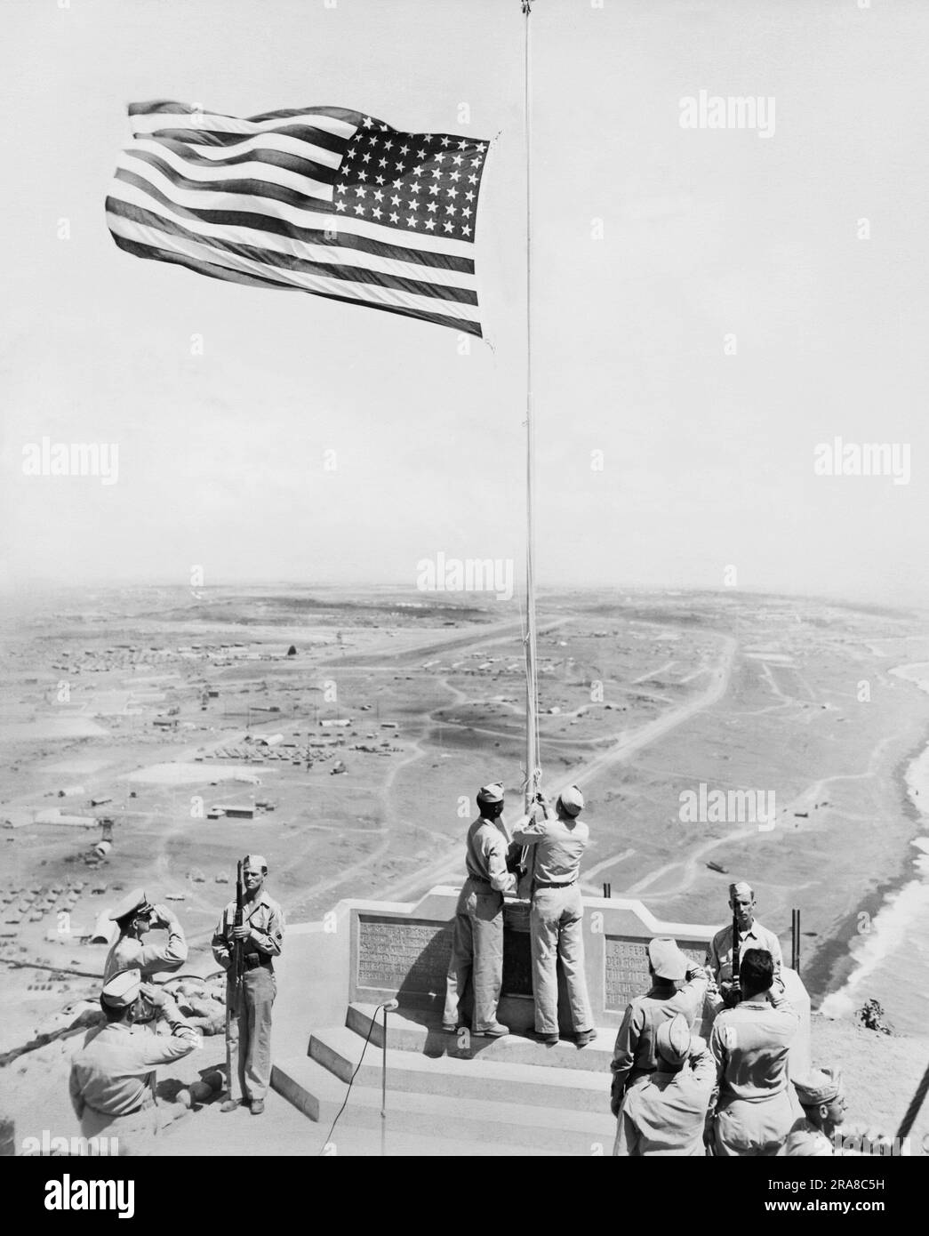 Iwo Jima, Japon: c. 1955 cérémonie du drapeau américain au monument sur le mont Suribachi sur Iwo Jima où Joe Rosenthal a pris sa photo emblématique. Banque D'Images