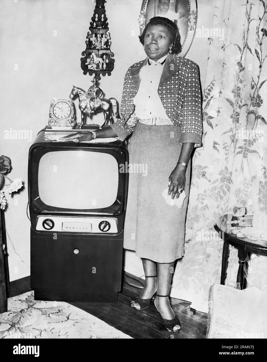 San Francisco, Californie: c. 1953 Une femme d'âge moyen est fière de son téléviseur Admiral installé dans son salon. Banque D'Images