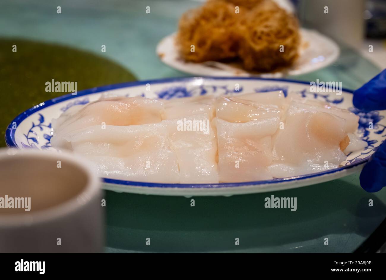 Main tenant le plat de Yumcha sur la table. Dim sum cuisine chinoise. Auckland. Banque D'Images
