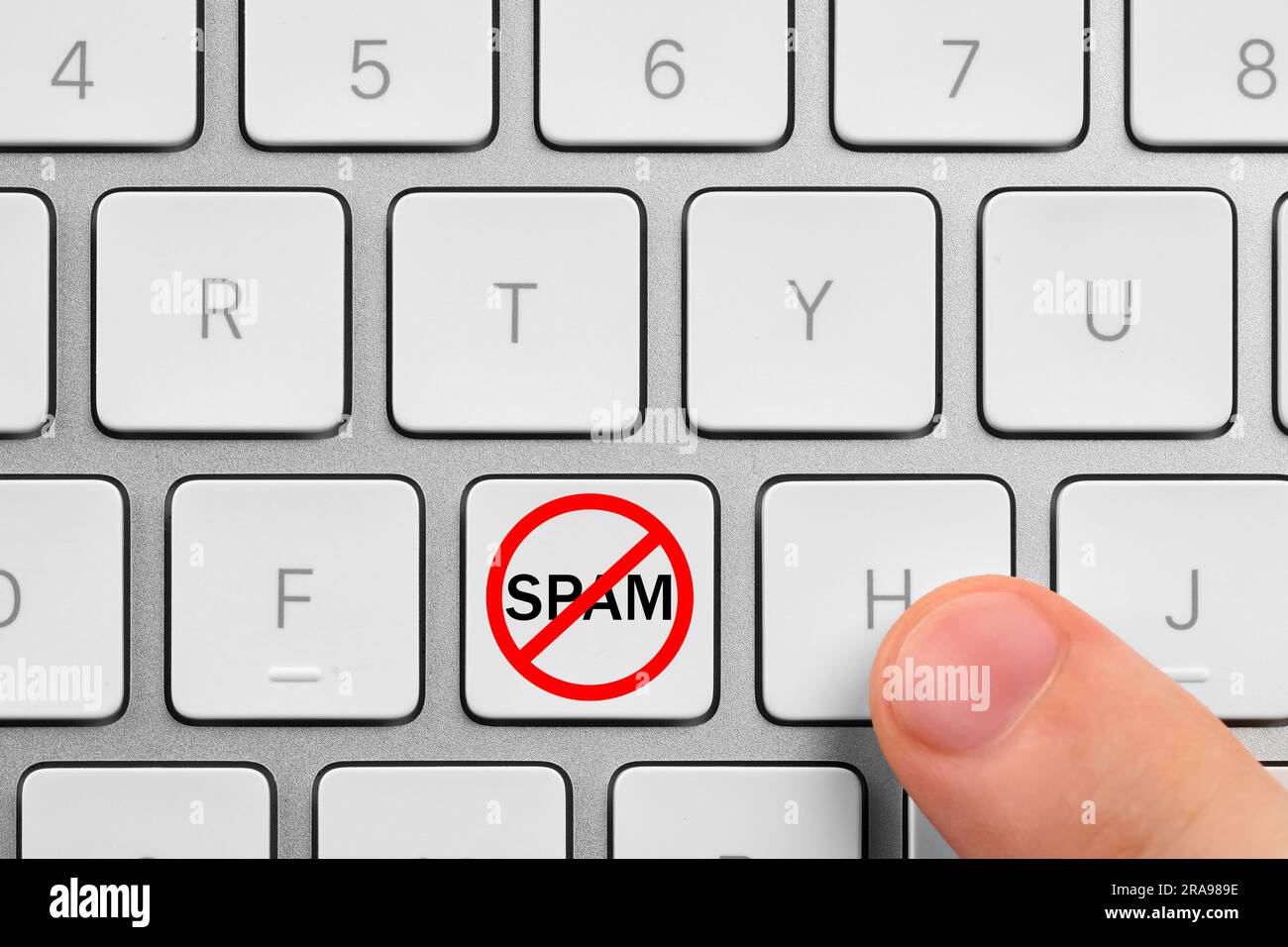Panneau d'interdiction avec le mot Spam sur le bouton, vue de dessus. Homme utilisant un clavier d'ordinateur, gros plan Banque D'Images