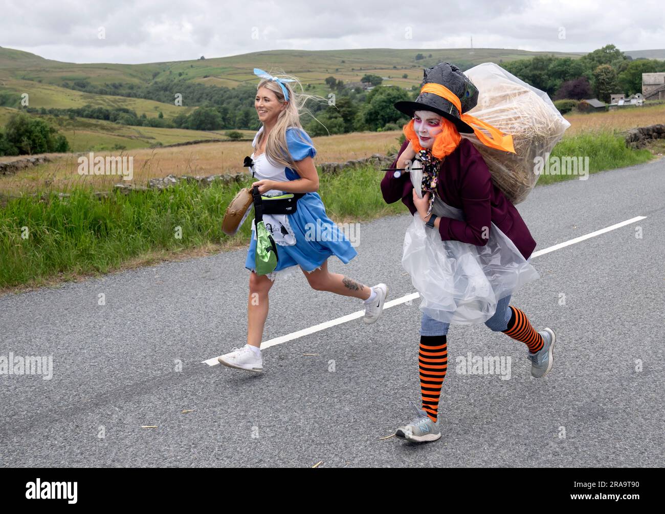 Les concurrents prennent part à la course de paille d'Oxenhope dans le West Yorkshire, une course de 2,5 kilomètres en costume fantaisie tout en portant une balle de paille de 20kg sur le trajet. Date de la photo: Dimanche 2 juillet 2023. La course a lieu chaque été dans le village Pennine d'Oxenhope, et a été lancé par deux hommes qui avaient un pari sur qui pourrait gagner une course d'un pub à l'autre portant une balle de paille. Le crédit photo devrait se lire comme suit : Danny Lawson/PA Wire Banque D'Images