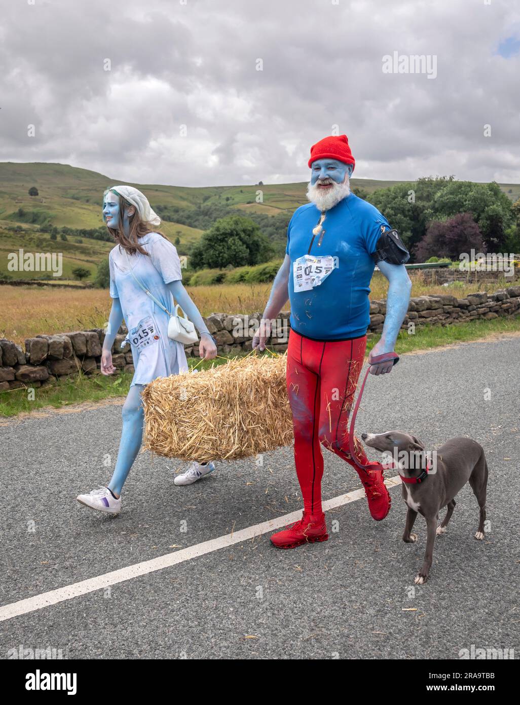 Les concurrents prennent part à la course de paille d'Oxenhope dans le West Yorkshire, une course de 2,5 kilomètres en costume fantaisie tout en portant une balle de paille de 20kg sur le trajet. Date de la photo: Dimanche 2 juillet 2023. La course a lieu chaque été dans le village Pennine d'Oxenhope, et a été lancé par deux hommes qui avaient un pari sur qui pourrait gagner une course d'un pub à l'autre portant une balle de paille. Le crédit photo devrait se lire comme suit : Danny Lawson/PA Wire Banque D'Images