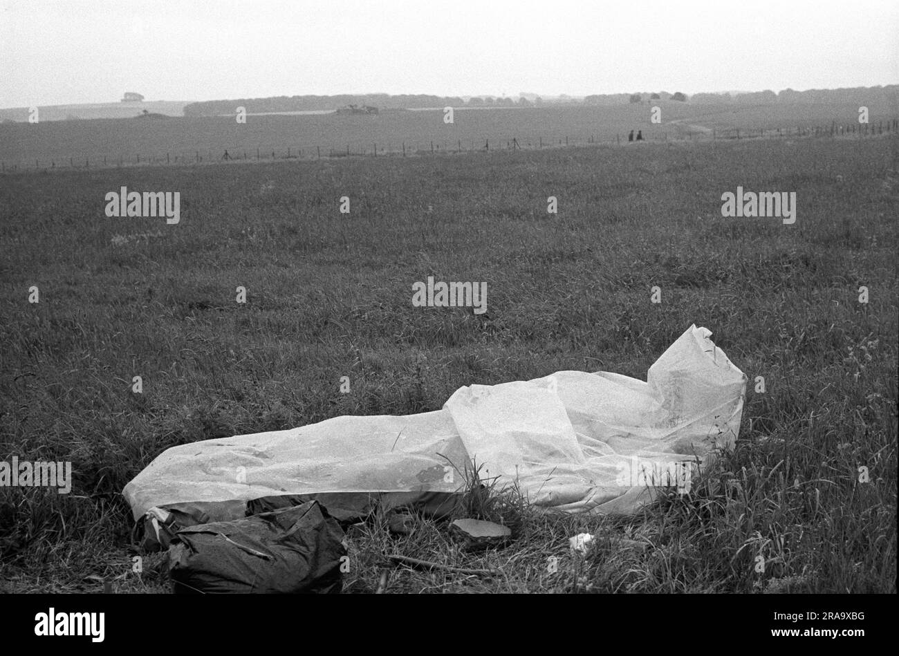 Stonehenge Free Festival au solstice d'été, Wiltshire, Angleterre vers juin 1976. Pluie d'été un hippy dort dans un sac de couchage étanche Make Shift. 1970S ROYAUME-UNI HOMER SYKES Banque D'Images